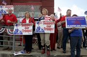 Borah Van Dormolen, of Salado, Texas, center, stands Saturday with other supporters of President Bush in downtown Crawford, Texas, near President Bush's ranch.