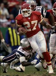 Kansas City running back Larry Johnson (27) tries to give the slip to New England safety Eugene Wilson (26) in the Chiefs' 26-16 victory over the Patriots. Johnson rushed for 119 yards in the Chiefs victory Sunday in Kansas City, Mo.
