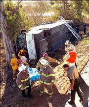 Rescue personnel remove one of two people killed when a Greyhound bus flipped over Sunday in Santa Maria, Calif. The bus was headed from Los Angeles to San Francisco when it rolled onto its side, killing two and injuring more than three dozen others.
