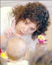Kelly Smith signs "duck" to Katy Friesen during class in Newton. Smith, a Kindermusik educator at the Joyful Noise Music Studio, teaches parents and children to sign to improve communication through a music-and-sign-language program called "Sign and Sing."