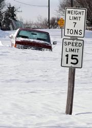 A pickup truck is shown stuck in a snowdrift Tuesday following a blizzard that ripped through Warner, S.D.