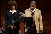 Barbara Becnel, executive director of Neighborhood House of North Richmond, and actor Jamie Foxx, holding a cell phone, listen to a jail call Wednesday from Stanley Tookie Williams, as part of a rally to demonstrate against the pending execution of Williams in Los Angeles. The co-founder of the Crips gang is scheduled to be executed Dec. 13.