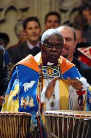 John Sentamu, the new Archbishop of York, center, plays the bongos during his enthronement service Wednesday in York Minster, York, England. Sentamu is the first black archbishop in the nearly 500-year history of the Church of England.