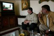 Two Iraqi men watch a TV news broadcast showing Westerners held captive as they sit inside a cafe in Basra, Iraq. The Iraqi group holding the hostages - two Canadians, a Briton and an American - have threatened to kill them if demands are not met by Dec. 8.