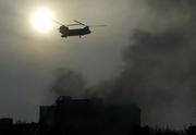 A helicopter flies above the building where a plane crashed in Tehran, Iran. An Iranian military transport plane crashed into a 10-story apartment building in the suburbs of the capital Tuesday, killing at least 115 people, according to state media and Tehran's mayor.