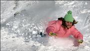 Haley Blansit, 12, slides down a snow-covered hill in Overland Park. A winter storm passed through the area, closing schools Thursday and leaving as much as a foot of snow in northeast Kansas.