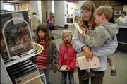 Members of the Gard family, of Lawrence, look for videos to check out of the Lawrence Public Library for a snow day of movies. From left are Sydney, 8, Elise, 6, their mother, Cathy Gard, and Alex, 3. "They come here all the time," said Cathy Gard. "Especially when they have programs." Next month the Lawrence City Commission will began to gather more details for a new public library.