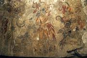 The National Geographic Society has released a photo showing a detail from a Mayan mural found at San Bartolo in Guatemala. The mural depicts the birth of the cosmos and the divine right of a king, and this portion shows the son of the maize god, patron of kings, with a pair of birds tied to his woven hunting basket, letting blood and offering a sacrificed turkey before one of five cosmic trees, according to the society.