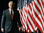 President Bush makes his entrance Wednesday before speaking in defense of his war policy at the Woodrow Wilson Center in Washington. The president is banking on a successful election in Iraq - which would establish Iraq's first permanent, democratically elected government - to signal that his war plan is working.