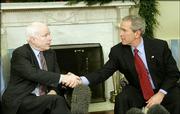 President Bush shakes hands Thursday with Sen. John McCain, R-Ariz., at the White House. The White House has agreed to ban cruel treatment of prisoners.