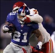 New York's Tiki Barber (21) escapes the grasp of Kansas City's Lional Dalton in the fourth quarter of the Giants' 27-17 victory. New York won Saturday in East Rutherford, N.J.