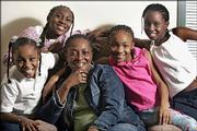 Mary McCray, center, sits Thursday in her apartment in Chicago with her granddaughters, from left, Wilshondra, 8, Rabriel, 12, Keoka, 9, and Mari, 10. Despite what they've been through, the girls are excited about Christmas in their new city.