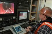 I-CON employee Geoff Hanson, of Ottawa, checks sewer connections using a remote-controlled TV camera.