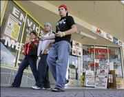 Migrant workers walk by Homestead, Fla., businesses used by foreign workers to send money to their families in Central America. Immigrants send billions of dollars back to their native countries each year, especially around the holiday season, but U.S. banks have struggled to make gains in the market.