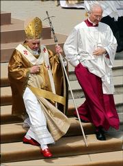 Wind blows as Pope Benedict XVI celebrates his installment Mass in St. Peter's Square at the Vatican while wearing his well-known bright red Prada loafers. He also is known for wearing Gucci sunglasses.