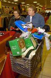 Sherry Hunt, of Gardner, and Debbie Wilper, of Garnett, fill a cart with post-Christmas sale items at J.C. Penney, 3311 Iowa, at 8 a.m. Monday. The shopping buddies arrived in Lawrence a little after 7 a.m. to get a head start on buying gifts for next year's holiday season.
