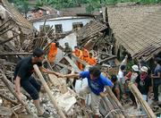 Rescuers and people from neighboring villages search among the wreckage of Cijeruk village for survivors after tons of mud loosened by monsoon rains buried the village Wednesday in Banjarnegara district, Central Java, Indonesia. Landslides triggered by monsoon rains have killed or left missing more than 170 people on Indonesia's Java island.