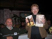 Sue Leonard, a volunteer at the Dole Institute of Politics, won signed copies of two books written by Bob Dole during the door prize drawings at the Dole Institute's volunteer and student recognition luncheon at Paisano's Ristorante. More than 30 volunteers, students and guests attended the Dec. 10 event. At left is Alan Miller, of Lawrence, husband of Sandi Miller, a Dole archive volunteer.