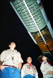 From left, James Simmons, Thomas Bollig and Andrew Morgan view a cutaway model of the Saturn V moon rocket during Baldwin Boy Scout Troop 65's visit to the Kansas Cosmosphere in Hutchinson. They visited the center Dec. 10.