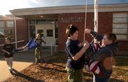 Williamstown Grade School fifth-graders Nick Alvarez, center, and Jeff Kirk remove the American flag from its pole as Caleb Richmond and Bailey Seetin work to fold the Kansas flag at the end of school Friday.