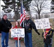 Kevin Nikes, left, president of Local 919 of the American Federation of Government Employees, talks with Brandin Raney, center, and his children, Samantha Raney, 10, and Logan Raney, 8. The Raneys, from Weston, Mo., joined prison workers at the U.S. Penitentiary to protest staff reductions and other issues.