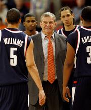 Connecticut coach Jim Calhoun is surrounded by his players during a timeout against Providence. The Huskies beat the Friars, 76-62, Saturday in Providence, R.I.