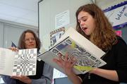 Pamina Buechner, right, an eighth-grader at West Junior High School, reads from "Broken," a book of poems she wrote and illustrated, while teacher Lynn Burlingham displays the illustrations. West students read from their books Tuesday during an Author&squot;s Tea at the school. The students&squot; books will be placed in the school library.