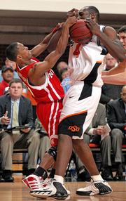 Nebraska's Charles Richardson, left, fights for the ball with Oklahoma State's Mario Boggan. The Huskers beat the Cowboys, 59-57, Tuesday in Stillwater, Okla.