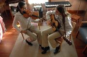 Shannon O'Shea, 13, and her sister Erika, 15, Lawrence, play "Bonaparte Crossing the Rocky Mountains" on Tuesday during a lesson at the Americana Academy of Music, 1419 Mass. City commissioners will consider proposals from the Americana Music Academy and Lawrence Parks and Recreation Department for taking over the Carnegie building at Ninth and Vermont streets at a March 9 study session