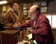 Lawrence gunsmith Doug Coffman puts the finishing touches on a shotgun he repaired for Lawrence resident Doug Yoder, left, Wednesday afternoon at Coffman's Repair and Custom Gunsmith Shop. As an avid gun enthusiast, Coffman sees nothing wrong with the idea of carrying a concealed weapon as long as the individual passes a background check and receives proper training on handling firearms.
