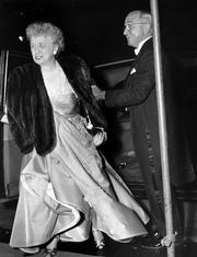 A smiling President Harry S. Truman helps his wife, first lady Elizabeth Truman, from their car in front of a Washington hotel in this April 2, 1952, file photo, as they arrive for a dinner at which they entertained Queen Juliana and Prince Bernhard, of the Netherlands.
