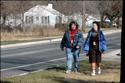 Denise Gonzales, Olathe, left, and Michelle Swain, Baldwin, both employees at the Social and Rehabilitation Services area office, 1901 Delaware St. walk near the area of a proposed city park. The planned park would be a trail head park for the rails-to-trails project that follows an abandoned railroad line. The trail head would be located near the white houses visible in the photograph at upper left on the north side of Delaware.