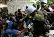 Guatemalan U.N. peacekeepers unsuccessfully try to stop angry supporters of Haitian presidential candidate Rene Preval from entering the upscale Hotel Montana in the Petionville suburb of Port-au-Prince, Haiti, Monday, Feb. 13, 2006, where election officials will announce results of the presidential elections. Protests erupted across the capital as vote counts showed that Preval may have fallen short of the 50 percent needed to win the presidency without a runoff election. The protesters allege the electoral commission is manipulating the vote count to prevent a first-round Preval victory.