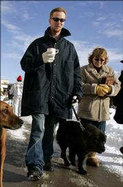 Inmate John Manard, left, is followed by Safe Harbor Prison Dog Program President Toby Young as he walks his dog on the grounds of the Lansing Correctional Facility in Lansing, Kan. in this photo taken Dec, 8, 2005. Manard, in prison for first-degree murder, aggravated robbery and possession of firearms, escaped from prison Sunday. Feb. 12, 2006. Young, who worked with Manard in the dog rescue program, is missing, and authorities said Monday that she may be with Manard.