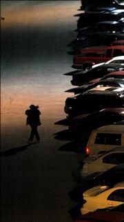 A women walks alone through a parking lot on the KU campus. Three years ago, following a rash of sexual assaults, a new program Jaywalk, was created at KU providing nighttime escorts for coeds worried about their safety while navigating campus after dark. But despite those concerns the service has gone unused.