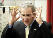 President Bush pretends to adjust his safety glasses during his tour of the Johnson Control Battery Technology Center, Monday, Feb. 20, 2006, in Glendale, Wis.