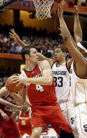 Louisville's David Padgett, left, is pressured by Syracuse's Terrence Roberts (33) and Darryl Watkins during Saturday's game in Syracuse, N.Y. Louisville announced Tuesday that Padgett would miss the rest of the season because of a knee injury.