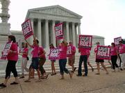 Planned Parenthood advocates who support a woman's right to an abortion march in front of the U.S. Supreme Court in July. Justices have agreed to consider reinstating a ban on late-term abortions.