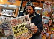 A vendor reads a newspaper with its front page showing Bosnian Serb war crimes fugitive Gen. Ratko Mladic, at his newsstand in the Serbian capital, Belgrade. Mladic, charged with genocide for some of the worst atrocities of the Bosnian war, has been located and authorities are negotiating his surrender, senior state security officials said Tuesday. The headline reads "Mladic surrounded."