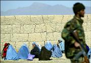 A soldier of the Afghan National Army stands guard as the relatives of prisoners wait outside the Policharki Prison in Kabul, Afghanistan , Monday, Feb. 27, 2006. Security forces with tanks and heavy guns surrounded Kabul's main prison Monday, as authorities sought to resume negotiations with rioting prisoners but warned they could use force.