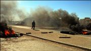 A Kut resident walks past burning tires after a demonstration in Kut, 100 miles southeast of Baghdad, Iraq. Thousands of Kut residents took to the streets in an anti-government rally Sunday to protest against fuel shortages and an increase in gasoline prices. The struggle to form a broad-based governing coalition acceptable to all the country's main groups has been further hampered by the surge in sectarian conflict. Pressure mounted Sunday on Prime Minister Ibrahim al-Jaafari to give up his bid for a new term.