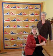 Some of Kansas University basketball's biggest stars are helping the Social Service League this year in its annual effort to buy shoes for Lawrence children. The league will be auctioning a quilt signed by 41 current and former KU basketball players and coaches on eBay. The auction is set to begin at 6 tonight. With the quilt Wednesday are designer and quilter Barbara Brackman, left, and quilter Deb Rowden.