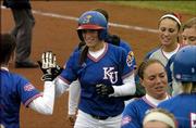 Kansas University's Jessica Moppin is congratulated after her home run against Minnesota. The Jayhawks split a doubleheader Friday at Arrocha Ballpark in the Jayhawk Classic, beating Minnesota, 6-3, but falling to Eastern Michigan, 2-1.