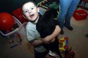 Ethan Folks, 5, enjoys a moment with his dog in his play room. Ethan's mom, Jacqui Folks, along with Rebecca Dority, are searching for members for an autism support group in Eudora.