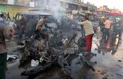Iraqi firefighters extinguish a fire at the site of a car bomb explosion Sunday in the Shiite district of Sadr City, in Baghdad, Iraq.