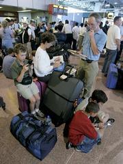 Passengers queue up with their baggage at Heathrow Airport in London. An estimated 30 million bags checked in at airports last year failed to arrive on time with their owners, a new report finds.