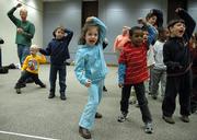 Center foreground: Marlee Coleman, 5, in blue, and Otulro Hussey, 6, wearing red, take protective stances and yell "Safe" during a self-defense, safety and awareness workshop Monday at the Lawrence Public Library. Instruction from the ATA Blackbelt and Leadership Academy came with all three workshops. The academy recently participated in a fundraiser to aid orphans in Mexico and India.