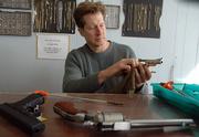 Doug Wahl, owner of Lawrence Pawn and Jewelry, 944 E. 23rd St., cleans a gun at his shop. He says that people who are scared enough to think they need to carry a concealed firearm probably already have one.