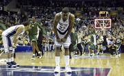 Connecticut's Rudy Gay (22) bends over in shock and dismay as George Mason University's Patriots storm onto the court. George Mason defeated UConn, 86-84 in overtime, Sunday in the Verizon Center in Washington. The Patriots will meet Florida in the Final Four on Saturday in Indianapolis.