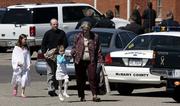 Members of the Fourth Street Church of Christ in Selmer, Tenn., walk back to their vehicles through a patrolled parking lot after services Sunday. The recent death of their pastor, Matthew Winkler, and the subsequent arrest of his wife for the alleged murder tempered the discussions in both Sunday School and general services.
